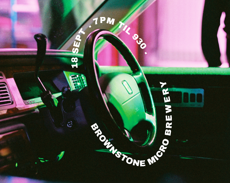 Neon sign with steering wheel design and event details for a dinner car meet at Brownstone Micro Brewery.